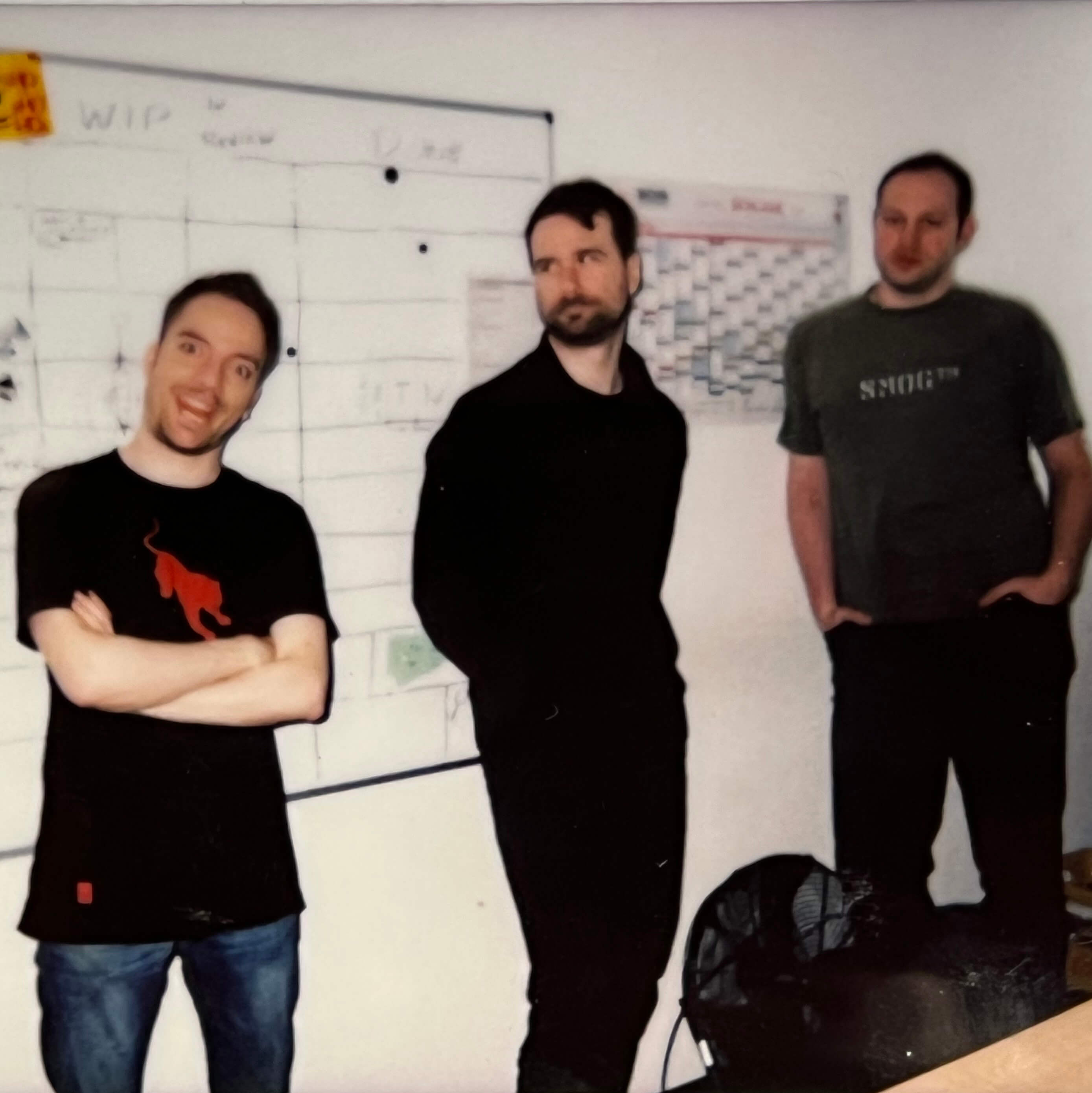 Three Keen employees standing together in front of a whiteboard